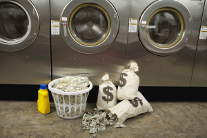 Bags and baskets full of money in front of laundry machines