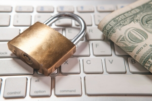A lock and money on top of a keyboard representing crypto fraud